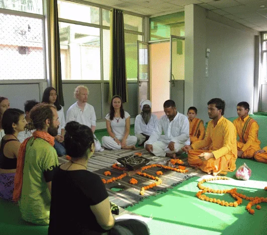 Founder and students at a ceremony in the yoga hall at Avatar Yoga School