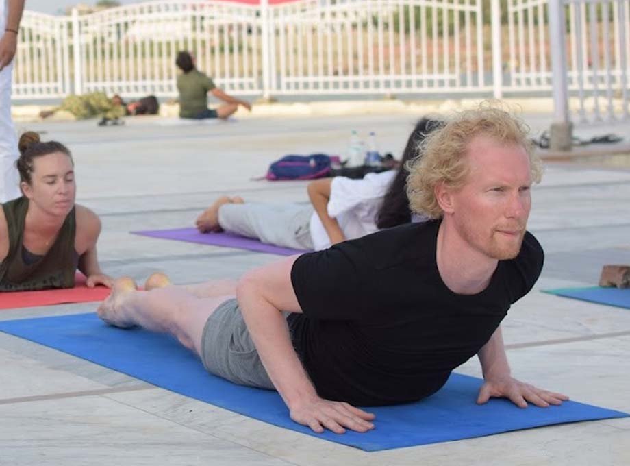 Yin yoga pose with a bolster during teacher training in Rishikesh