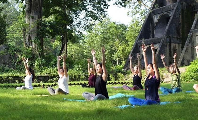 Yoga teacher correcting a student's pose in class